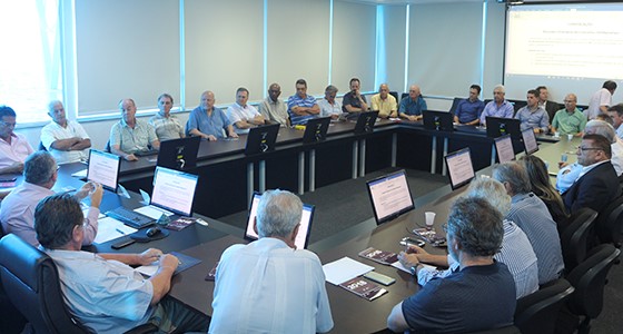 Grande mesa retangular com diversos homens sentados à volta