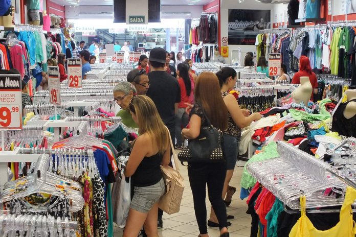 Pessoas escolhem produtos de vestuário em um feira de comércio