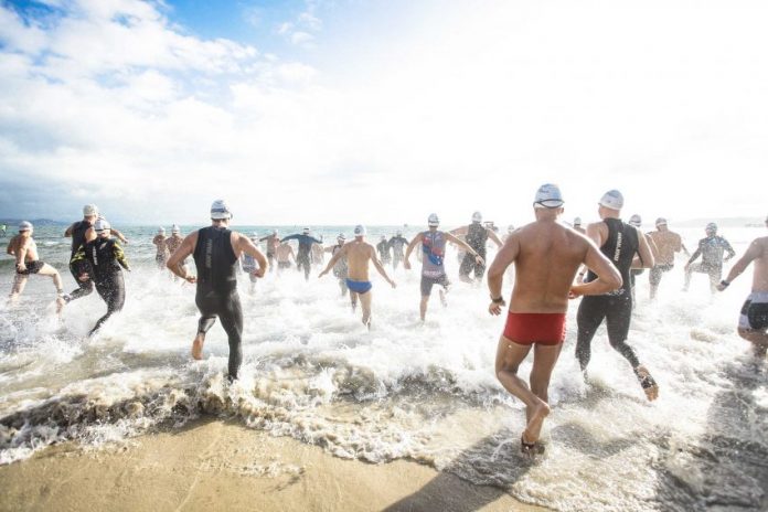 Nadadores correndo em direção ao mar