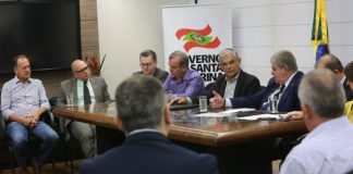 Mesa de reunião com políticos em apenas um lado para coletiva de imprensa