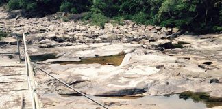 Foto do leito rochoso do rio com pouca água