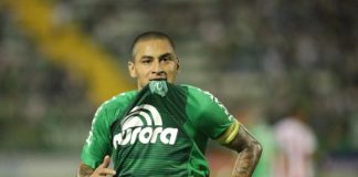 Jogador Wellington Paulista corre em campo com o brasão da camisa na boca