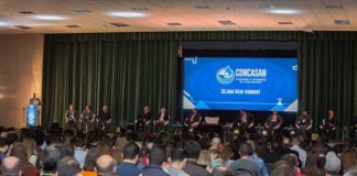 público sentado assistindo a uma palestra em um auditório