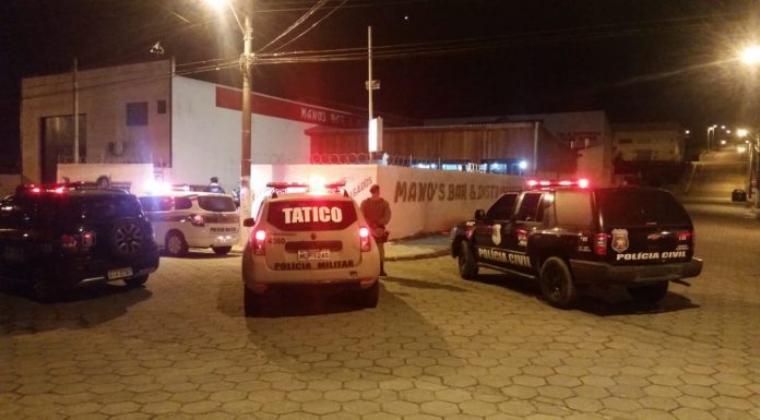 carros da polícia parados à noite em uma esquina com giroflex ligado