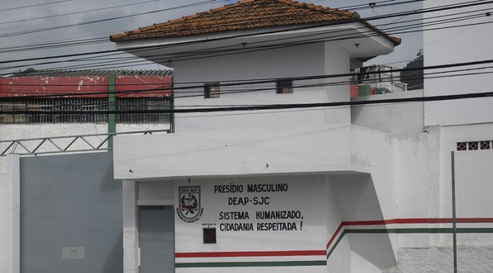 parte do portão de entrada de um presídio com guarita e inscrições do deap