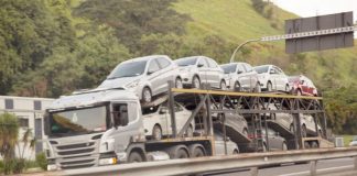 caminhão cegonha carregado cruza em velocidade uma estrada