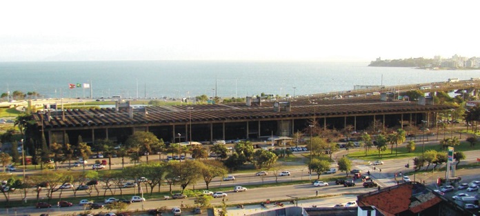 rodoviária vista de longe e de cima, com avenida na frente, arborizada, ao fundo o mar e as pontes