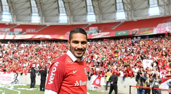 o jogadore guerrero com a camisa do internacional faz gesto de positivo para a câmera dentro do estádio lotado de torcedores