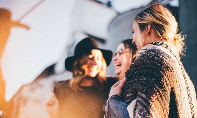 três mulheres dão risadas juntas