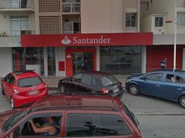 fachada da agência do santander com alguns carros parados na frente