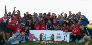 grupo de atletas posa mostrando medalhas em um gramado