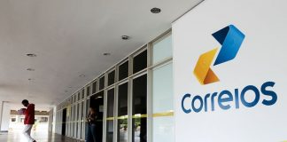 fachada externa de uma agência dos correios cuja porta de entrada fica em uma galeria