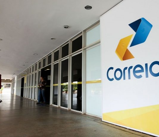 fachada externa de uma agência dos correios cuja porta de entrada fica em uma galeria