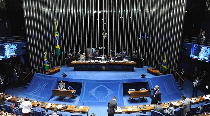 salão do senado visto de cima mostrando à mesa diretora ao centro e bancadas na parte de baixo da foto, com pessoas espalhadas