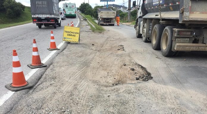 trecho de areia entre duas vias de asfalto com sinalização de cones e caminhões estacionados