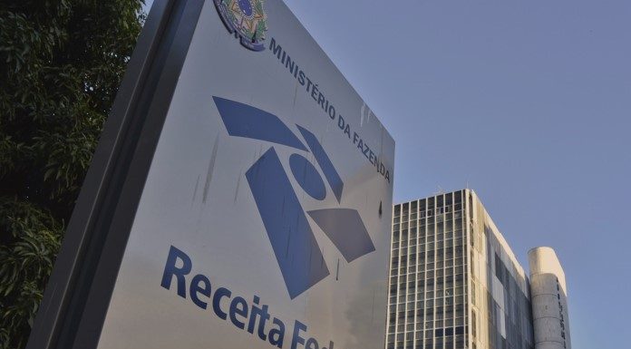 fachada externa de prédio da receita federal com o logo e inscrição em placa