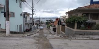 rua com trecho ao centro com asfalto novo, por onde passou a obra