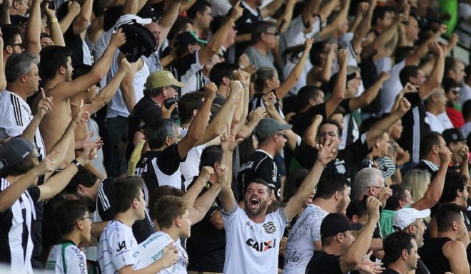 torcida do figueirense em pé em que todos estão com os braços levantados