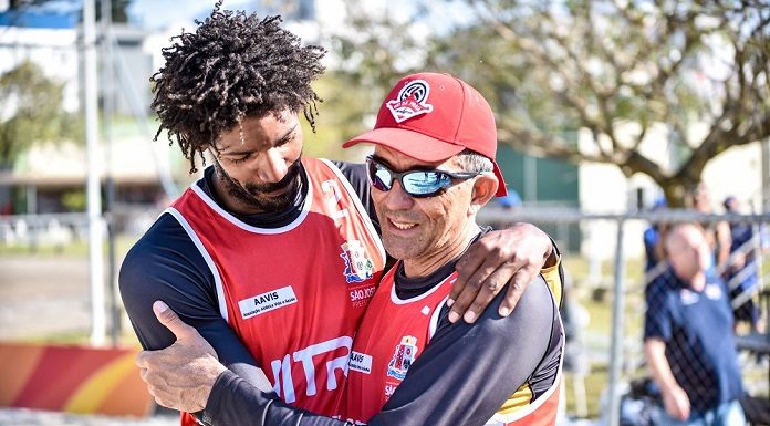 os dois homens com o uniforme de são jose se abraçam em comemoração