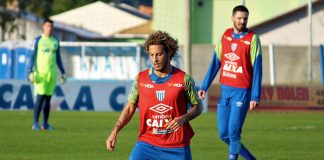 jogador guga em treino do avaí carrega a bola, observado por outros jogadores ao fundo