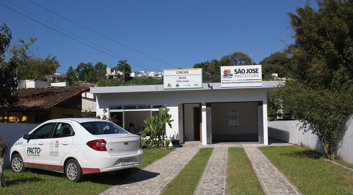 área externa da casa, com um jardim e carro novo sedan (KA) estacionado