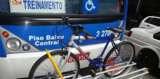 bicicleta encaixada em suporte à frente de um ônibus