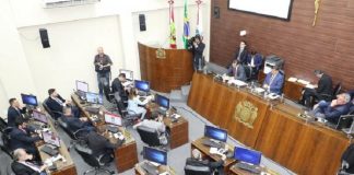 parlamento da câmara, onde vereadores estão sentados nas mesas, visto de cima em dia de sessão