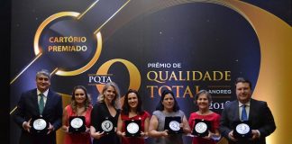 sete pessoas posam para a foto mostrando os troféus recebidos