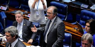 senador fala em pé ao microfone visto de cima entre outros senadores sentados nas bancadas