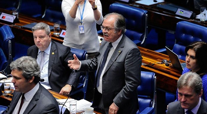 senador fala em pé ao microfone visto de cima entre outros senadores sentados nas bancadas