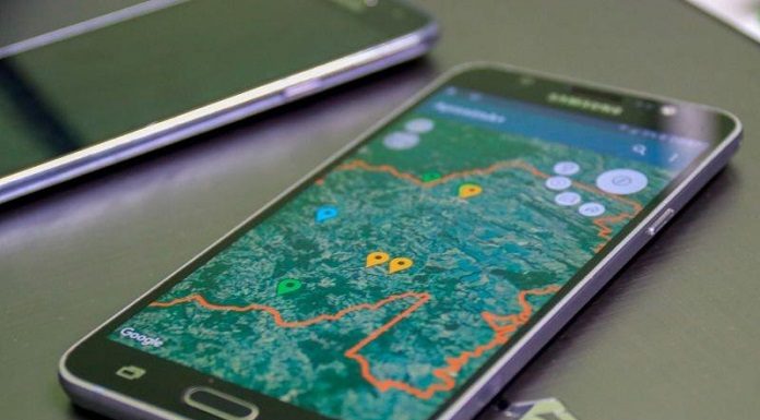 smartphone sobre uma mesa com um mapa de uma cidade na tela e pontos marcados