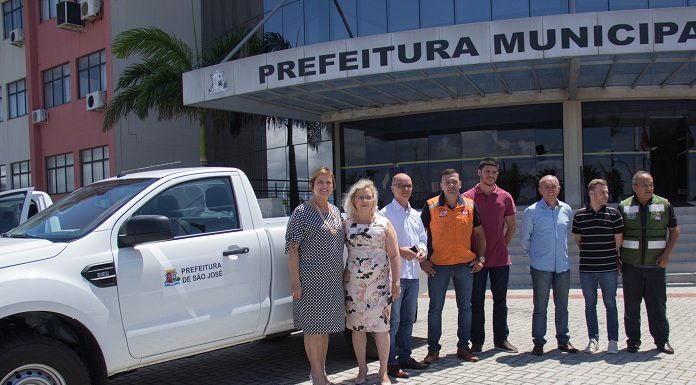 prefeita adeliana, secretária andrea pacheco e outras pessoas posam para foto ao lado de uma caminhonete com o logo da prefeitura de são josé