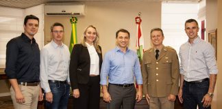 grupo posa sorridente para a foto em gabinete com bandeiras