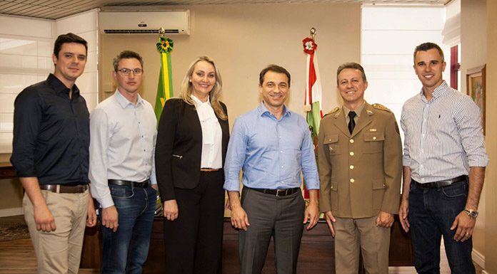 grupo posa sorridente para a foto em gabinete com bandeiras