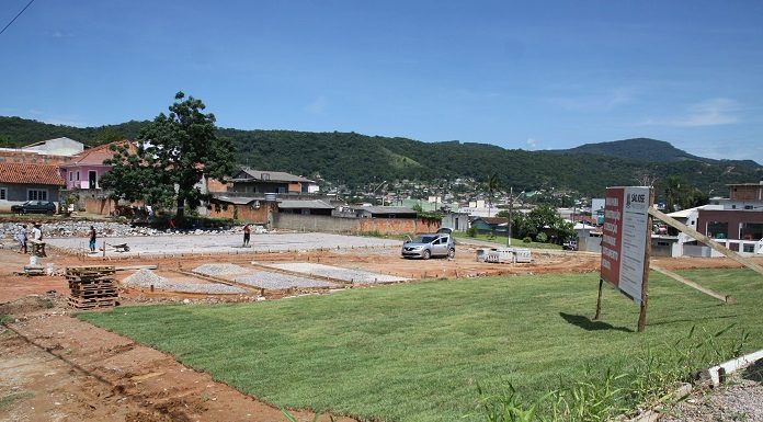 área aberta em construção a com gramado em pequeno declive no meio de uma área residencial