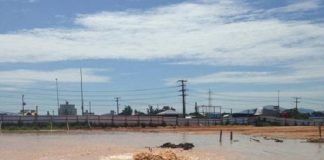 grade lago barrento formado em área aberta de onde sai do meio uma fonte de água, adutora rompida no solo