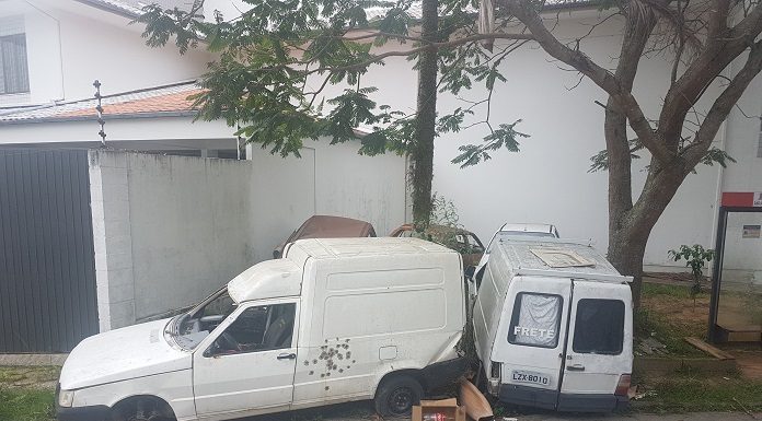 duas fiorinos arrombadas encostadas ao lado da rua e em cima de uma calçada