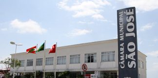 foto externa do prédio camara de vereadores de são Joosé com um placa vertical na frente e carros estacionados