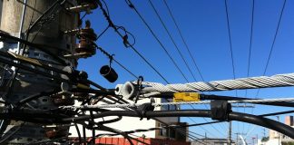 close no topo de um poste com dezenas de fios de energia emaranhados na avenida jousé di bernardi em são josé