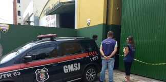 viatura da guarda municipal estacionada em frente ao portão da empresa com fiscais da susp de colete ao lado