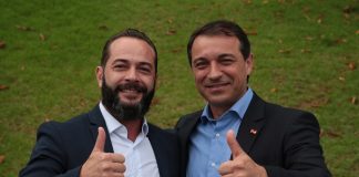 comin e moisés abraçados sorriem e fazem sinal de positivo para a câmera