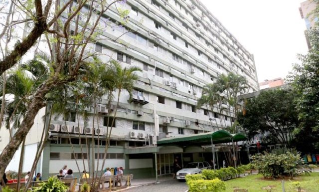 fachada do prédio de oito andares com jardim na frente