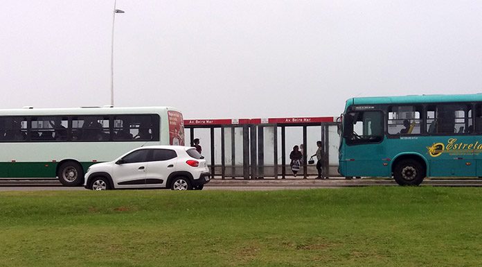 um ônibus da estrela atrás de um ônibus da jotur na beira-mar de são josé e um carro passando na frente