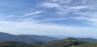 montanhas com vegetação a perder de vista e céu azul com poucas nuvens