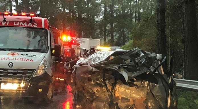 carro destruído no acostamento com ambulâncias ao lado