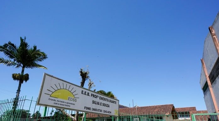 portão de entrada do colégio com placa com nome por extenso