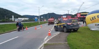 caminhonete da prf ao lado de balão inflável na lei seca sobre canteiro ao lado de marginal onde há cones