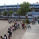 foto do prédio e do pátio do instituto estadual de educação com alunos em uma fila