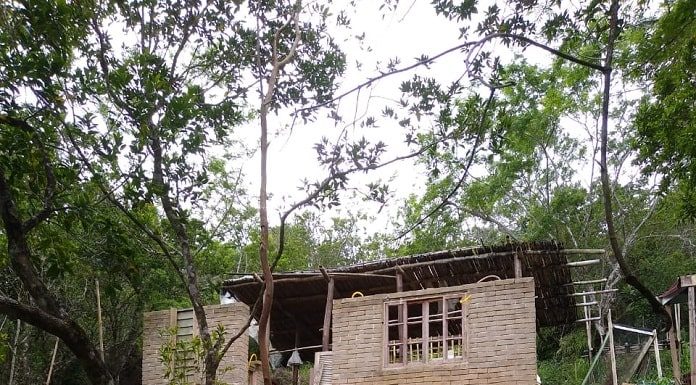 casa de tijolos precária no alto de um morro com mata em volta