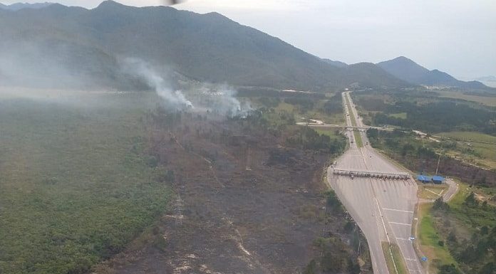 foto aérea da área queimada ao lado da rodovia com pedágio